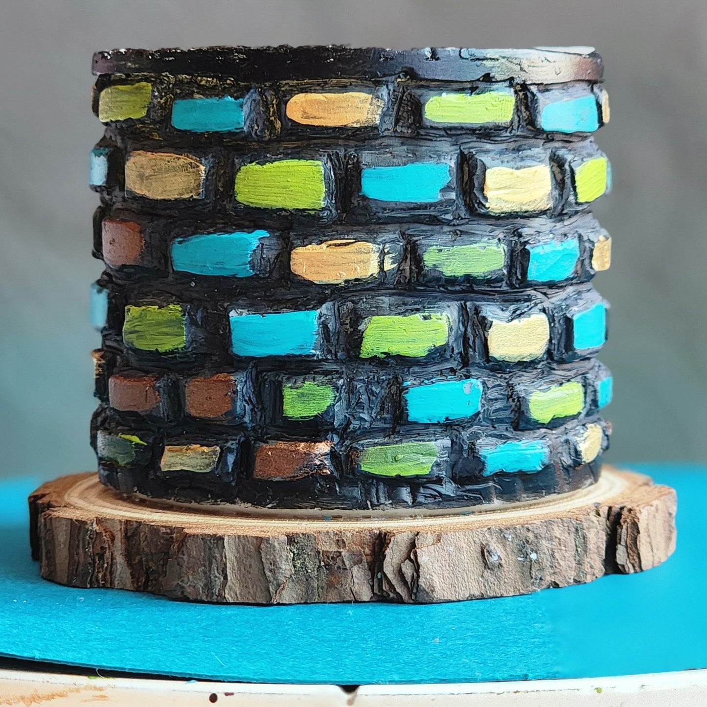 Colorful brick-patterned cake on a wooden stand with a blue background