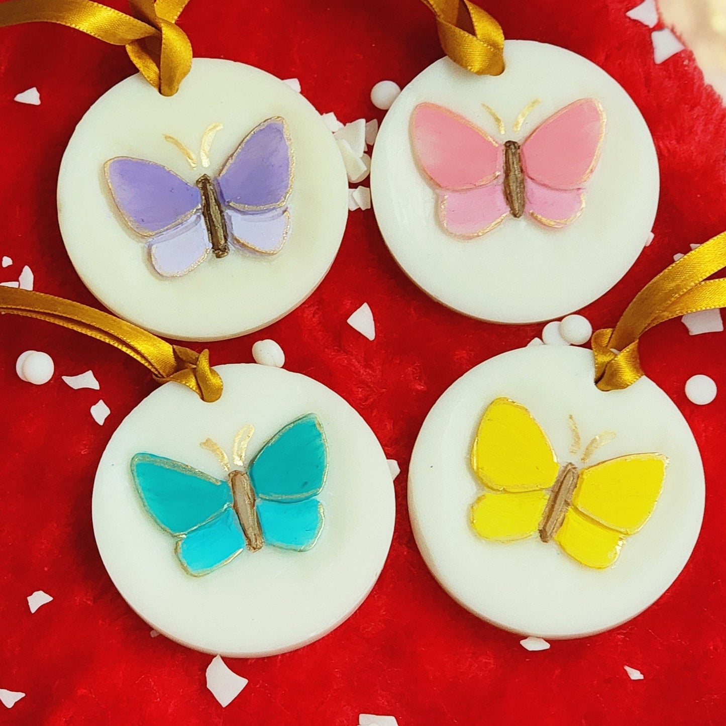 Decorative items with colorful wax butterflies on a red fabric background